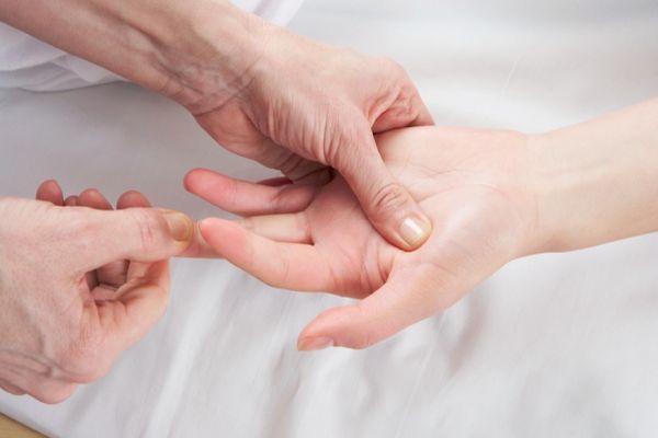 image of acupressure applied to a hand - illustrates the benefits of acupressure treatment